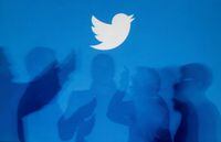 FILE PHOTO: The shadows of people holding mobile phones are cast onto a backdrop projected with the Twitter logo in this illustration picture taken in  Warsaw September 27, 2013. REUTERS/Kacper Pempel