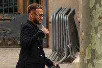 Paris Saint-Germain's Brazilian forward Neymar gestures as he leaves leaves after attending the opening audience at the courthouse in Barcelona on October 17, 2022, on the first day of his trial. - With the World Cup barely a month away, Brazilian superstar Neymar goes on trial in Spain over alleged irregularities in his transfer to Barcelona nearly a decade ago. The 30-year-old was acompanied by his parents, who are also in the dock on corruption-related charges over his 2013 transfer from the Brazilian club Santos. (Photo by Pau BARRENA / AFP) (Photo by PAU BARRENA/AFP via Getty Images)