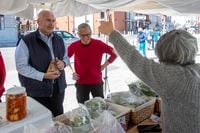 Kingston market vendor Sarah Attwelll gives a thumb up after Ontario Liberal Leader Steven Del Duca bought some jam some jams in Kingston, Ont., Saturday, May 7, 2022. THE CANADIAN PRESS/Lars Hagberg