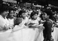 FILE - In this June 5, 1983, file photo, Dianne Durham, right, of Gary, Ind., gives autographs after winning the women's title at the McDonald's U.S.A. Gymnastic Championships at the University of Illinois in Chicago. Durham, the first Black woman to win a USA Gymnastics national championship, died on Thursday, Feb. 4, 2021, She was 52. (AP Photo/Lisa Genesen, File)