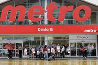 Customers, workers and security stand outside a Metro grocery store in Toronto, Saturday, July 29, 2023. THE CANADIAN PRESS/Cole Burston