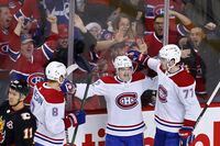 Montreal Canadiens' Cole Caufield, centre, celebrates his game-winning goal against the Calgary Flames with teammates Mike Matheson, left, and Kirby Dach during third period NHL hockey action in Calgary, Thursday, Dec. 1, 2022.  THE CANADIAN PRESS/Larry MacDougal