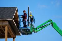 A construction worker works from a lift in a new housing development in Ottawa on Friday, Oct. 14, 2022. Canada Mortgage and Housing Corp. says the annual pace of housing starts in November edged down 0.2 per cent compared with October. THE CANADIAN PRESS/Sean Kilpatrick