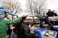 Cody Brooks hands out packages prosciutto, with Paddy Sullivan (in black), that was collected from a dumpster for people in need, from the back of a pick up truck in the parking lot of the Superstore in Vancouver, B.C., on April 16, 2023
Photo: Jennifer Gauthier