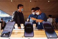 A customer talks to sales assistants in an Apple store as Apple Inc's new iPhone 14 models go on sale in Beijing, China, September 16, 2022.