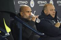 Manchester City's head coach Pep Guardiola sits on the bench before the English FA Cup 4th round soccer match between Manchester City and Arsenal at the Etihad Stadium in Manchester, England, Friday, Jan. 27, 2023. (AP Photo/Dave Thompson)
