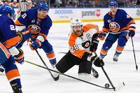 Jan 25, 2022; Elmont, New York, USA; dPhiladelphia Flyers center Claude Giroux (28) and New York Islanders left wing Zach Parise (11) battle for the puck during the third period at UBS Arena. Mandatory Credit: Dennis Schneidler-USA TODAY Sports