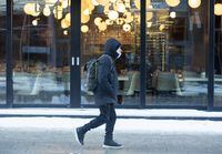 A man walks by an empty restaurant in Montreal, Thursday, January 20, 2022.&nbsp;Quebec is reporting a significant drop in COVID-19-related deaths today, with half of yesterday's tally for a total of 33 new deaths attributed to the novel coronavirus. THE CANADIAN PRESS/Graham Hughes