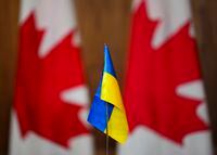 A Ukrainian flag is pictured in front of Canadian flags in Ottawa on Friday, April 1, 2022. A free new summer camp aims to help Ukrainian refugee children and their families settle in Montreal. THE CANADIAN PRESS/Sean Kilpatrick
