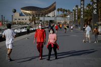 People walk along a seafront promenade in Barcelona, Spain, Saturday, May 2, 2020. Spaniards have filled the streets of the country to do exercise for the first time after seven weeks of confinement in their homes to fight the coronavirus pandemic. People ran, walked, or rode bicycles under a brilliant sunny sky in Barcelona on Saturday, where many flocked to the maritime promenade to get as close as possible to the still off-limits beach. People are supposed to respect a 1-measure distance, but the crowds in some spots made that impossible. (AP Photo/Emilio Morenatti)