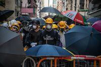 HONG KONG, CHINA - JULY 28: Masked protesters stand behind a makeshift barricade during a demonstration in the area of Sai Wan on July 28, 2019 in Hong Kong, China. Pro-democracy protesters have continued weekly rallies on the streets of Hong Kong against a controversial extradition bill since 9 June as the city plunged into crisis after waves of demonstrations and several violent clashes. Hong Kong's Chief Executive Carrie Lam apologized for introducing the bill and recently declared it "dead", however protesters have continued to draw large crowds with demands for Lam's resignation and completely withdraw the bill. (Photo by Laurel Chor/Getty Images)