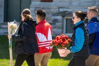 Cadets carry flowers at the Royal Military College in Kingston, Ontario on Friday April 29, 2022. The Department of National Defence says it's investigating an incident involving a vehicle at the Royal Military College campus. THE CANADIAN PRESS/Lars Hagberg