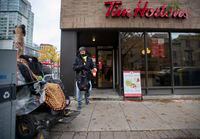 With his double double coffee in hand, George Wong walks out of the Tim Hortons coffee shop at Church St. and Adelaide St. East on Oct 21 2020. 