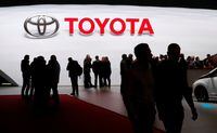 Visitors look at vehicles at the Toyota booth during the Geneva International Motor Show on March 7, 2018.