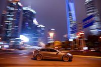 FILE PHOTO: A Tesla electric vehicle (EV) drives past a crossing in Shanghai, China March 9, 2021.  REUTERS/Aly Song/File Photo