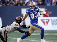 Winnipeg Blue Bombers' Dalton Schoen (83) escapes the tackle by B.C. Lions' T.J. Lee (6) to run the ball in for a touchdown during first half CFL action in Winnipeg Thursday, August 3, 2023. Dalton Schoen is confident he didn’t make a mistake by re-signing with the Winnipeg Blue Bombers. THE CANADIAN PRESS/John Woods