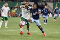 Oct 20, 2021; Portland, Oregon, USA; Vancouver Whitecaps forward Deiber Caicedo (7) battles for the ball with Portland Timbers midfielder George Fochive (20)  during the second half at Providence Park. Mandatory Credit: Soobum Im-USA TODAY Sports