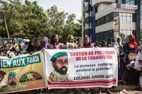 Supporters of new interim Malian President, Colonel Assimi Goita, hold up banners and react ahead of his swearing in ceremony in Bamako on June 7, 2021. (Photo by ANNIE RISEMBERG / AFP) (Photo by ANNIE RISEMBERG/AFP via Getty Images)