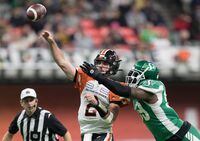 B.C. Lions quarterback Danny O'Brien (2) passes the ball as he's hit by Saskatchewan Roughriders' A.C. Leonard during the first half of a CFL football game in Vancouver, on Friday October 18, 2019. The CFL suspended Leonard for two games Friday for failing to provide a sample for drug testing.THE CANADIAN PRESS/Darryl Dyck