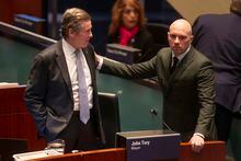 Mayor John Tory (left) talks to councillor Brad Bradford in the council chamber ahead of a budget meeting in Toronto,  on Wednesday, February 15, 2023.THE CANADIAN PRESS/Chris Young 