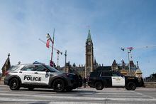 Toronto Police Service and Ontario Provincial Police (OPP) vehicles are seen on Wellington Street in preparation of U.S. President Joe Biden's visit in Ottawa, on Wednesday, March 22, 2023. THE CANADIAN PRESS/Spencer Colby