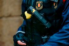 A Catalan autonomous police 'Mosso D'Esquadra' officer, carries a 'Taser' electroshock weapon during a police operation against drug consuming and trafficking in 'narco-pisos' or drug-flats on October 29, 2018, in Barcelona. - Hundreds of police backed by a helicopter raided dozens of squatted apartments in central Barcelona used for selling and consuming heroin and other drugs. A court in the northeastern Spanish city authorised the search of 40 suspected flats in the central Gotic and Raval neighbourhoods and several arrests are expected, according to a statement from the regional judiciary administration. (Photo by PAU BARRENA / AFP)PAU BARRENA/AFP/Getty Images