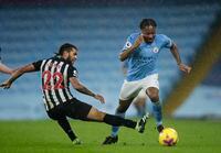 Manchester City's Raheem Sterling, right, and Newcastle's DeAndre Yedlin challenge for the ball during the English Premier League soccer match between Manchester City and Newcastle United at the Etihad Stadium in Manchester, England, Saturday, Dec., 26, 2020. (Clive Brunskill/ Pool via AP)