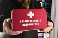 FILE - Debra Cross, director of operations for Provoking Hope, an addiction recovery center in McMinnville, Ore., displays an emergency kit used to treat opioid overdose as she stands inside an ambulance converted into a mobile needle-exchange unit on Dec. 9, 2021. Oregon Attorney General Ellen Rosenblum has announced an agreement with Oregon's cities and counties for the allocation of Oregon's approximately $329 million share of an historic $26 billion national settlement with the three largest distributors of opioids and the drug manufacturer. (AP Photo/Andrew Selsky, File)