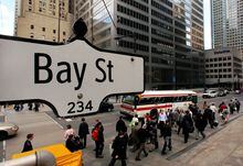 FILE PHOTO: The Bay Street sign is pictured in the heart of the financial district as people walk by in Toronto, May 22, 2008.     REUTERS/Mark Blinch (CANADA)/File Photo
