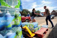FILE PHOTO: Volunteers carry drinking water at a distribution site while the city of Jackson is to go without reliable drinking water indefinitely after pumps at the water treatment plant failed, leading to the emergency distribution of bottled water and tanker trucks for 180,000 people, in Jackson, Mississippi, U.S., September 2, 2022.   REUTERS/Rory Doyle/File Photo