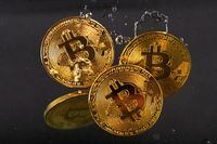 Souvenir tokens representing cryptocurrency Bitcoin plunge into water in this illustration taken May 17.