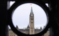 The Parliament Hill Peace Tower is framed in an iron fence on Wellington Street in Ottawa on Thursday, March 12, 2020.&nbsp;A 19-year-old Ottawa man has been arrested for allegedly posting numerous threatening tweets targeted at Parliament Hill, the Department of National Defence and two embassies. THE CANADIAN PRESS/Sean Kilpatrick