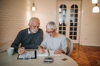 A senior couple taking a closer look at their budget in the comfort of their home.