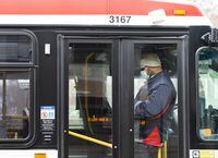 A TTC worker wears a mask in a bus while on shift in Toronto on Thursday, April 23, 2020.The Toronto Transit Commission says it's ending its mandatory COVID-19 vaccination requirement for workers and offering to reinstate employees who were terminated as a result of the policy.&nbsp;THE CANADIAN PRESS/Nathan Denette