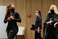 Serena Williams of the U.S., left, leaves after a press conference in which she announced her withdrawal from the tournament because of an Achilles injury prior to her second round match of the French Open tennis tournament at the Roland Garros stadium in Paris, France, Wednesday, Sept. 30, 2020. (AP Photo/Christophe Ena)