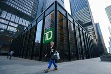 A person walks past a TD Bank sign in the financial district in Toronto on Tuesday, Sept. 20, 2022. As the Bank of Canada takes a backseat from hiking interest rates, economists say prices likely rose faster in January, but inflation is still expected to ease significantly in the coming months.THE CANADIAN PRESS/Alex Lupul