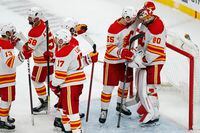 Calgary Flames' Noah Hanifin (55) celebrates with Dan Vladar after defeating the Boston Bruins during an NHL hockey game, Sunday, Nov. 21, 2021, in Boston. (AP Photo/Michael Dwyer)