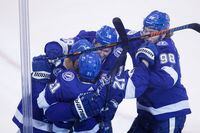 Tampa Bay Lightning centre Brayden Point is embraced by teammates to celebrate his overtime winner against the Columbus Blue Jackets Aug. 19, 2020. The Lightning won 5-4 in Game 5.