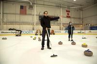 Jose Alcala calls a shot while curling at a Google Play team-building event in San Jose.