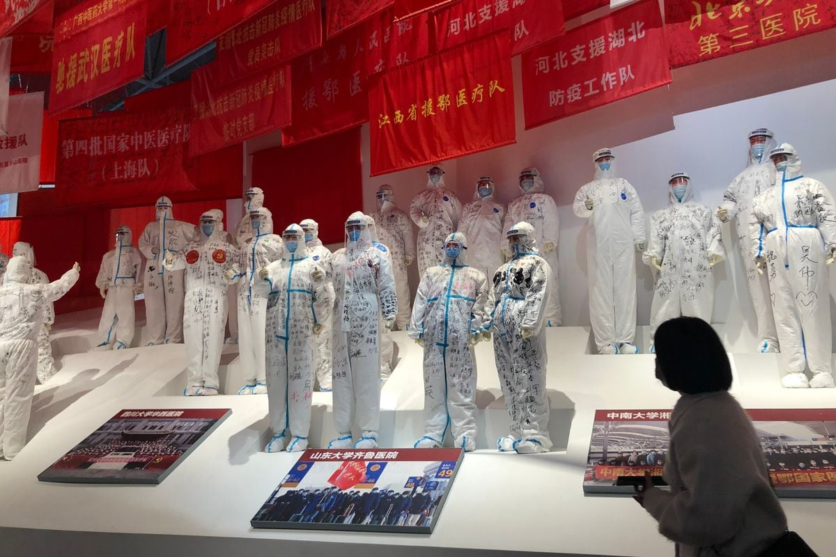 Un visiteur passe devant une exposition de travailleurs médicaux lors d'une exposition à Wuhan sur la réponse de la ville au COVID-19.