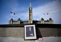 A framed portrait of former prime minister Brian Mulroney leans against the Centennial Flame on Parliament Hill  as Canadians mourn his death at the age of 84, in Ottawa, on Friday, March 1, 2024. THE CANADIAN PRESS/Justin Tang