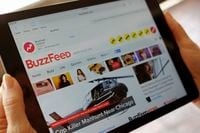 In this Sept. 2, 2015, file photo the BuzzFeed website is displayed on an iPad held by an Associated Press staffer in Los Angeles.