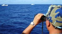 FILE PHOTO: FILE PHOTO: A crewman from the Vietnamese coastguard ship 8003 looks out at sea as Chinese coastguard vessels give chase to Vietnamese ships that came close to the Haiyang Shiyou 981, known in Vietnam as HD-981, oil rig in the South China Sea, July 15, 2014. Crewmen in blue camouflage uniforms pour out onto the deck of a Vietnamese coastguard ship as an imposing Chinese vessel guarding a giant oil rig gives chase, gathering steam by the second. A group of Chinese ships joined the pursuit, peeling away from a flotilla of about two-dozen vessels surrounding HD-981, the $1 billion rig that China deployed without notice in early May, triggering the worst breakdown in ties between the communist neighbours in three decades. Vietnam says this stretch of the South China Sea is in its 200-nautical mile exclusive economic zone and accuses China of bullying and trying to ram Vietnamese fishing vessels in the potentially energy-rich waters. China claims about nine-tenths of the South China Sea but insists it wants a peaceful resolution to the conflict.   Picture taken July 15, 2014.  REUTERS/Martin Petty (MID-SEA - Tags: POLITICS ENERGY CIVIL UNREST MARITIME MILITARY)/File Photo