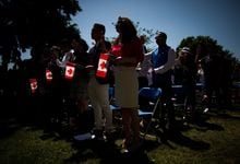 New Canadians, including Zahra Aminmoghaddam, centre, from Iran, take the oath of citizenship during a special Canada Day ceremony in West Vancouver, B.C., on Saturday, July 1, 2017. THE CANADIAN PRESS/Darryl Dyck