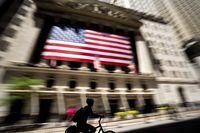 A person bikes past the New York Stock Exchange on Wednesday, June 29, 2022.