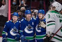 Vancouver Canucks' Quinn Hughes, from left to right, J.T. Miller and Bo Horvat celebrate Miller's goal against the Dallas Stars during the second period of an NHL hockey game in Vancouver, B.C., Sunday, Nov. 7, 2021.