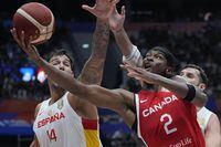 Canada guard Shai Gilgeous-Alexander (2) shoots against Spain center Willy Hernangomez (14) during the Basketball World Cup second round match between Spain and Canada at the Indonesia Arena stadium in Jakarta, Indonesia, Sunday, Sept. 3, 2023. (AP Photo/Achmad Ibrahim)