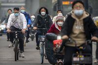 FILE - Commuters wearing face masks ride bicycles along a street in the central business district in Beijing, Thursday, Oct. 20, 2022. The World Health Organization downgraded its assessment of the coronavirus pandemic on Friday, May 5, 2023, saying it no longer qualifies as a global emergency. (AP Photo/Mark Schiefelbein, File)