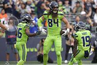 Seattle Seahawks tight end Colby Parkinson (84) celebrates with wide receiver Tyler Lockett, left, and wide receiver Penny Hart (19) after Parkinson caught a pass for a touchdown against the Denver Broncos during the first half of an NFL football game, Monday, Sept. 12, 2022, in Seattle. (AP Photo/Stephen Brashear)