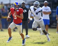 Los Angeles Rams quarterback Matthew Stafford runs from Dallas Cowboys defensive end Randy Gregory during NFL football practice on Saturday, Aug 7, 2021, in Oxnard, Calif. (AP Photo/John McCoy)